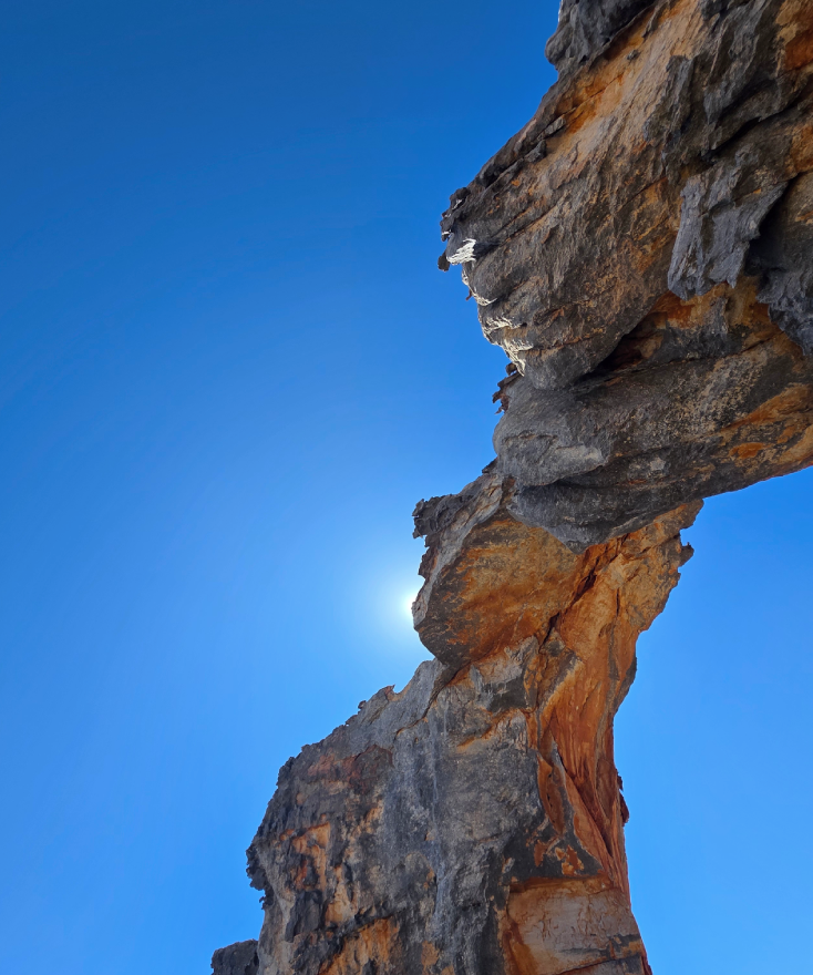 Reflection pool below a rock arch